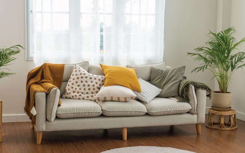 a couch with pillows in front of a large window