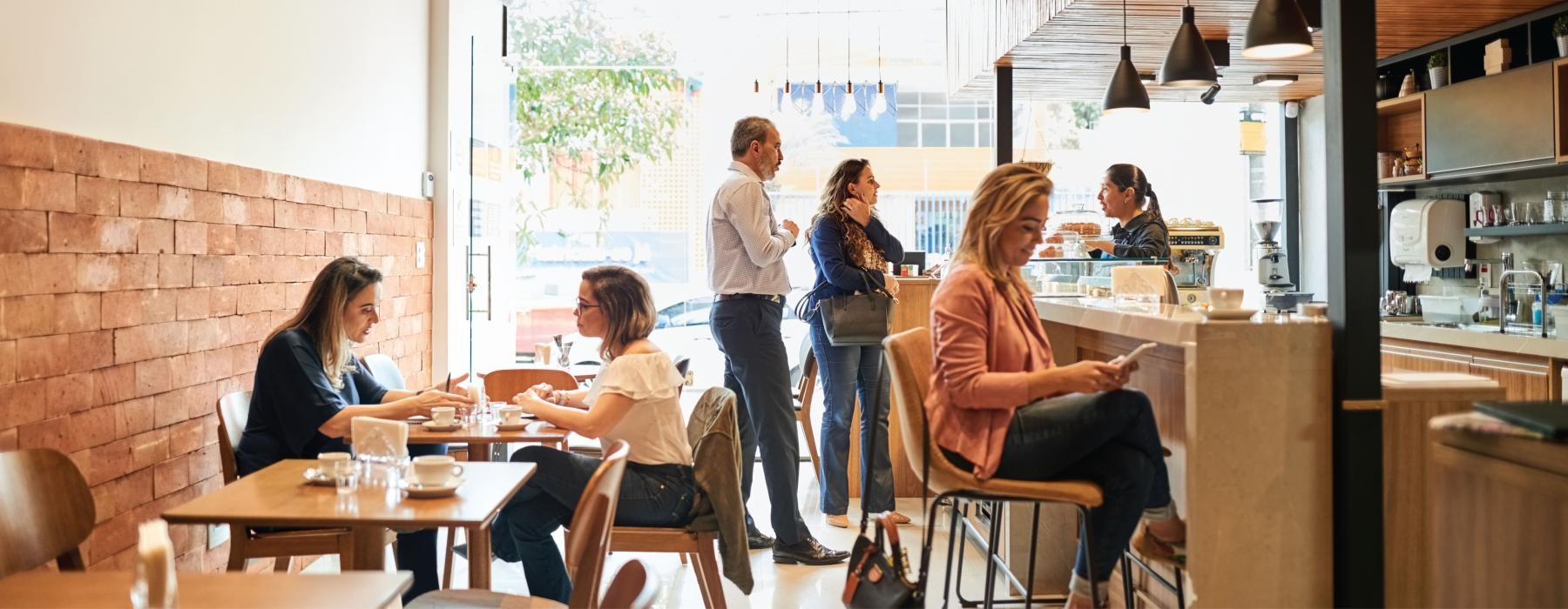 a group of people sitting around a table in a restaurant