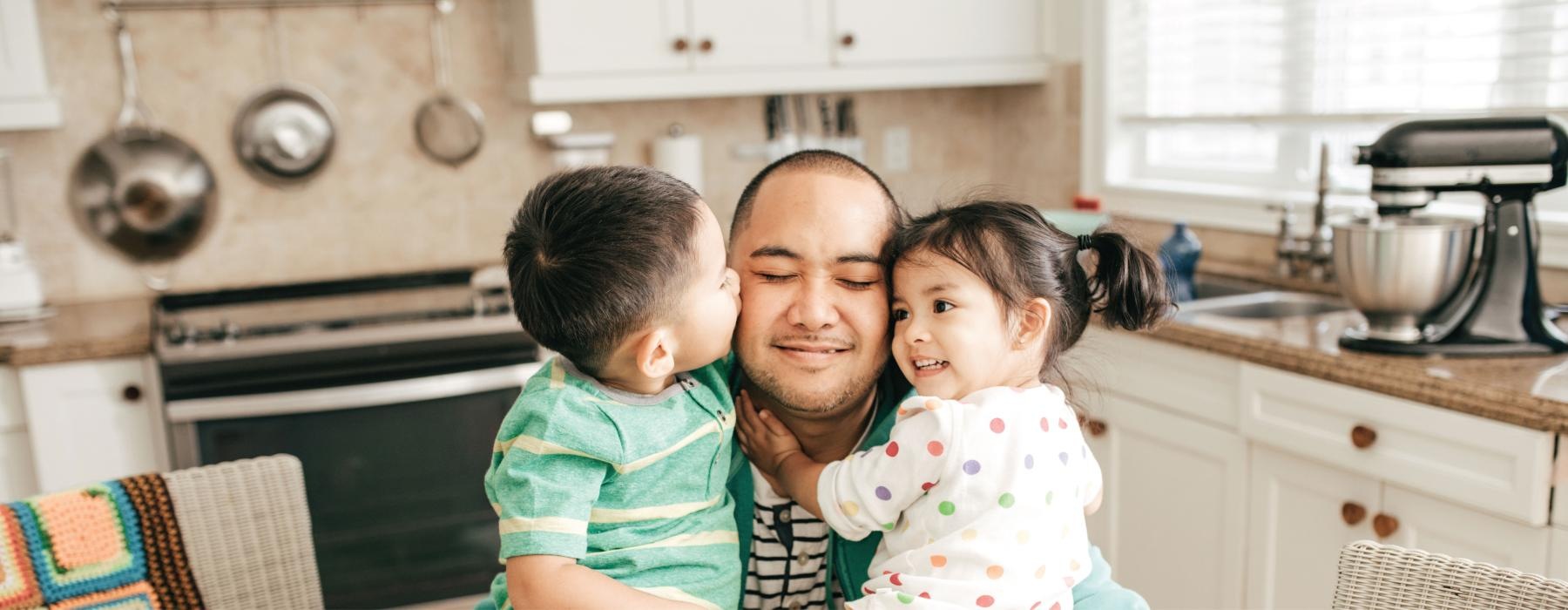 a person and a couple of children in a kitchen